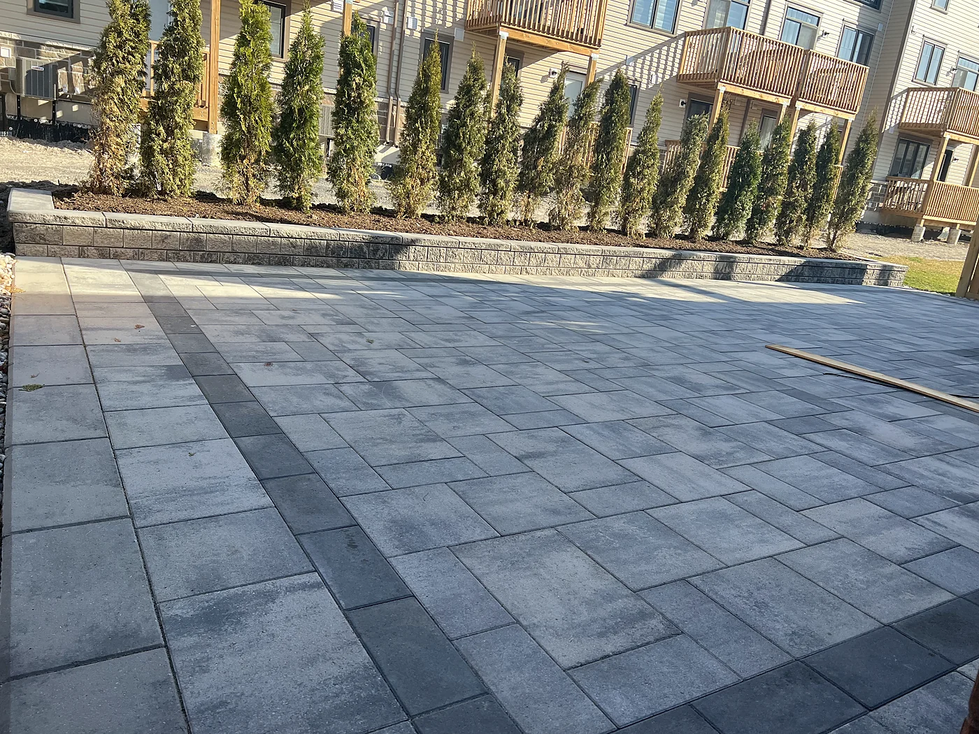 XY Landscaping backyard paving beside a raised planting bed